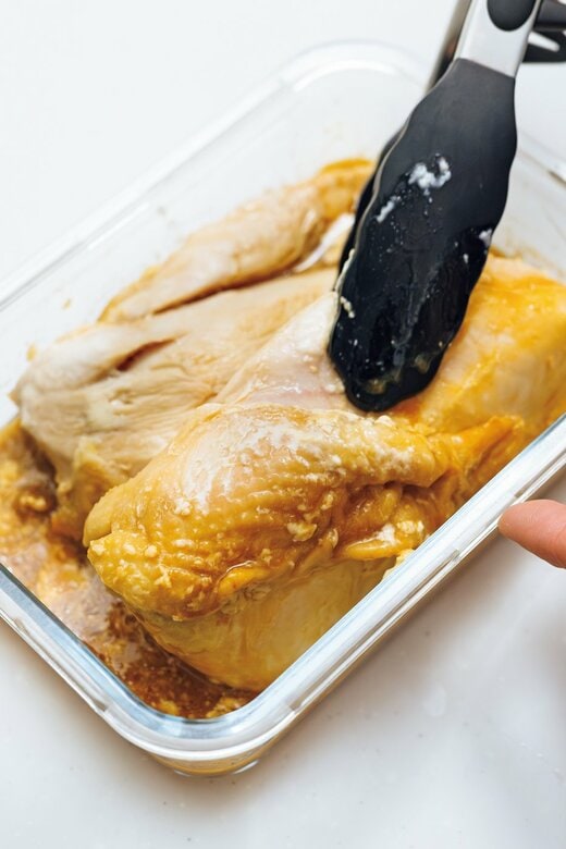 鶏胸肉をトングで挟む様子