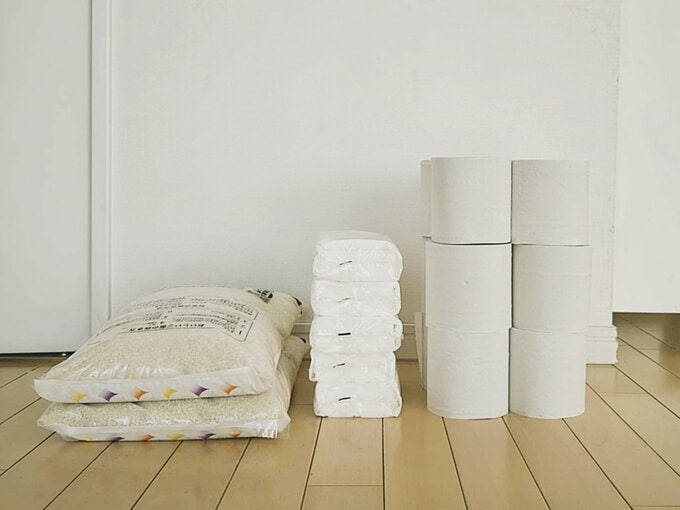 床に置かれた米2袋、ティッシュ、トイレットペーパー