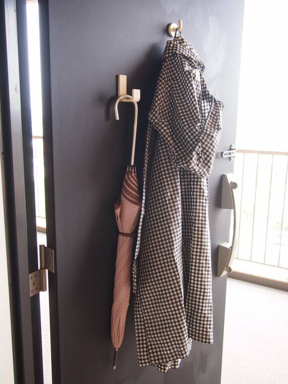 傘やレインコートをドアにつけれらるフックをつかって収納している様子