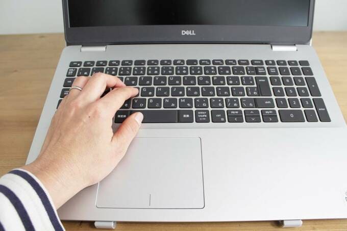 パソコンのキーボード部分に手