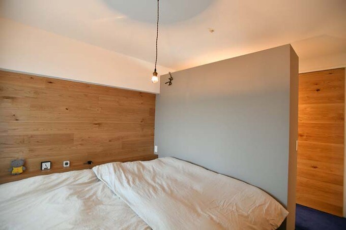 壁にナラの無垢板を採用した寝室