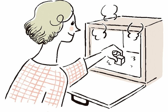 レンジをメラミンスポンジで掃除する女性