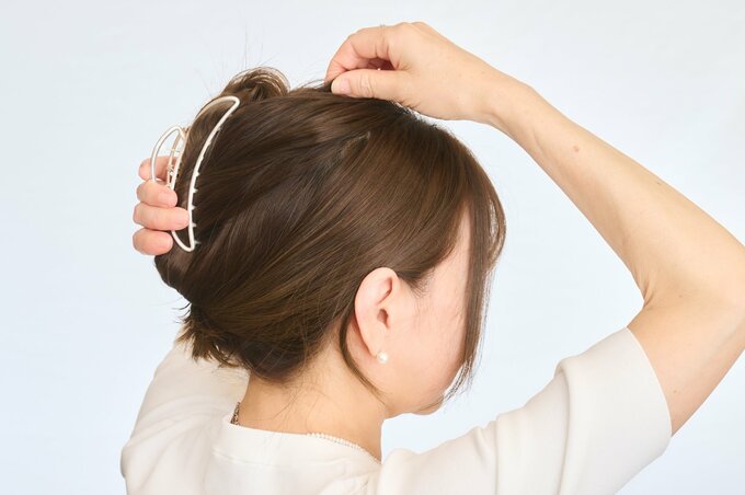 頭頂部の髪を引き出す女性