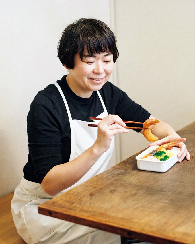 女性とエビフライ弁当