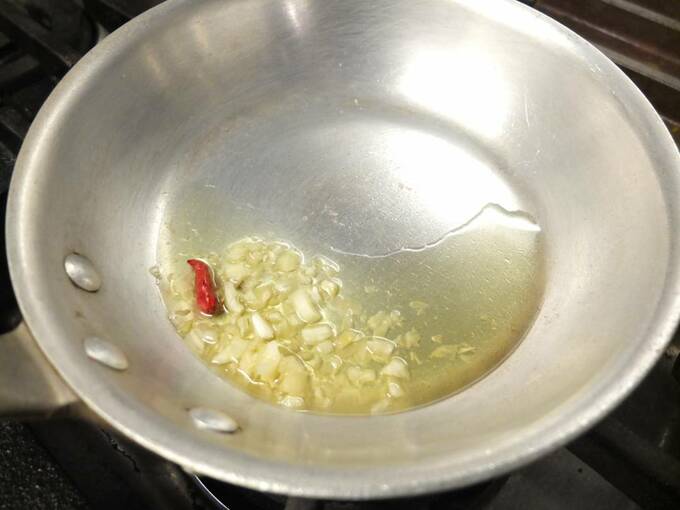 フライパンにニンニク一片と鷹の爪