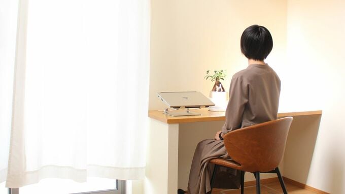 デスクに向かって座る女性の後ろ姿