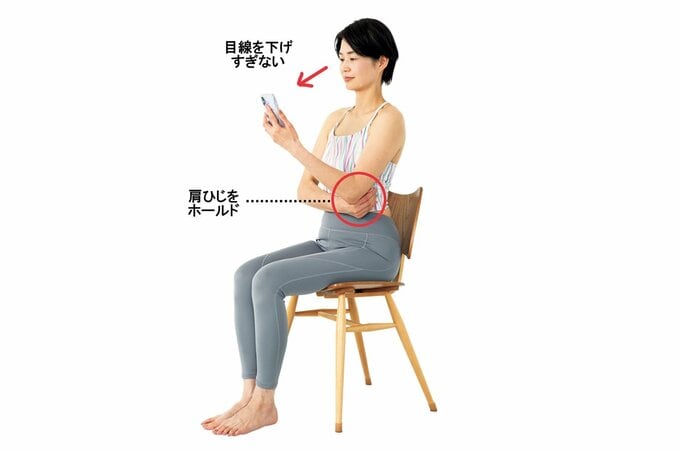 椅子に座ってスマホを操作する女性