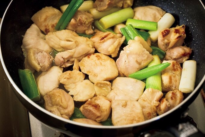 フライパンで肉とねぎを炒める