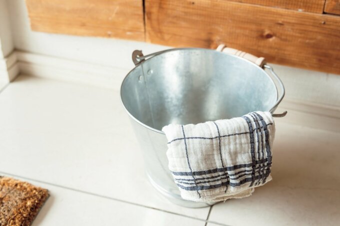 白と青のラインが入った雑巾をかけているアルミのバケツ