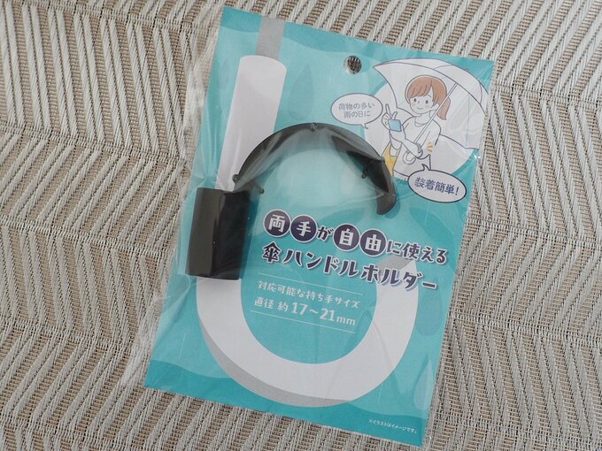 「両手が自由に使える 傘ハンドルホルダー」（110円）、対応可能な持ち手サイズ：直径約17～21mm、材質：PP、シリコンゴム