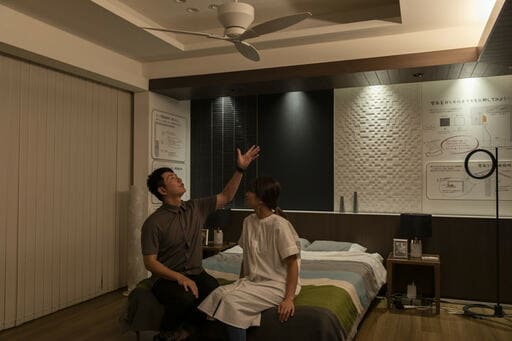 寝室でベッドに腰掛ける夫妻