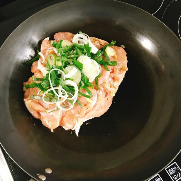  フライパンの半分のスペースに鶏肉、Aを入れてもみ込み、皮目を上にして置き、長ネギをのせる。