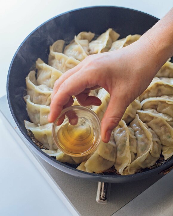 ギョーザにゴマ油を加える様子