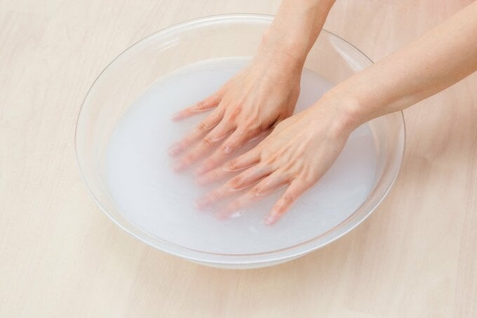 水をはった洗面器に両手をつける様子