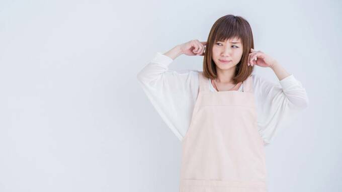 耳をふさぐ女性