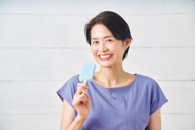 アイスを持って微笑んでいる短髪の女性