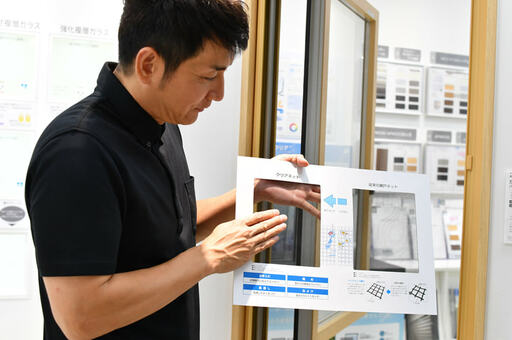 網戸の比較図を持つ男性