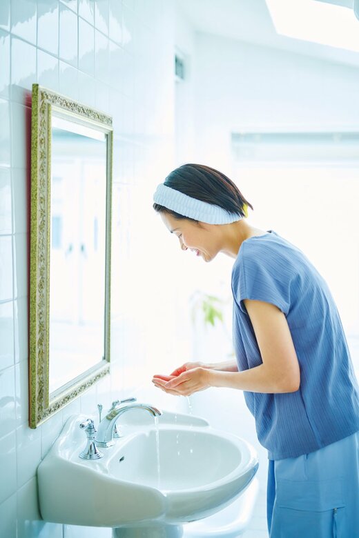 洗面所で洗顔をする女性