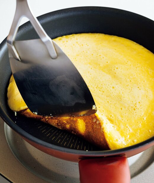 フライパンに入った生地をフライ返しで裏返す