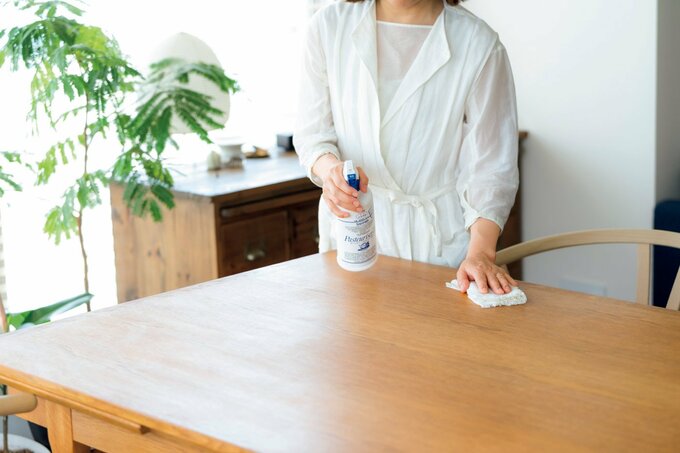 リビングのテーブルを拭く人