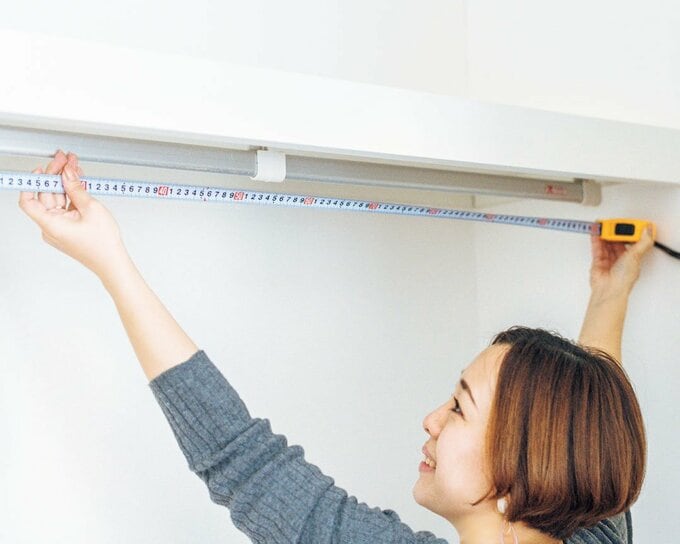 横幅を計る女性