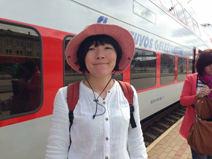帽子をかぶった女性後ろに電車