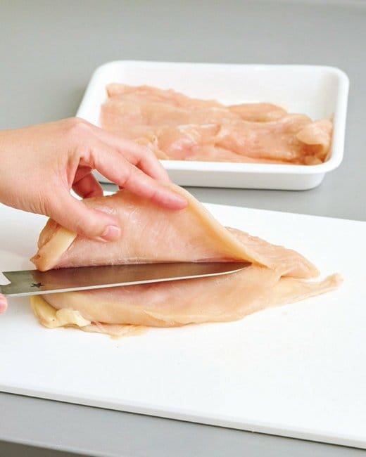 鶏肉を包丁で切る