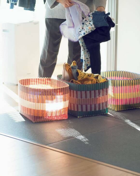 カゴ3つに衣類を入れる様子