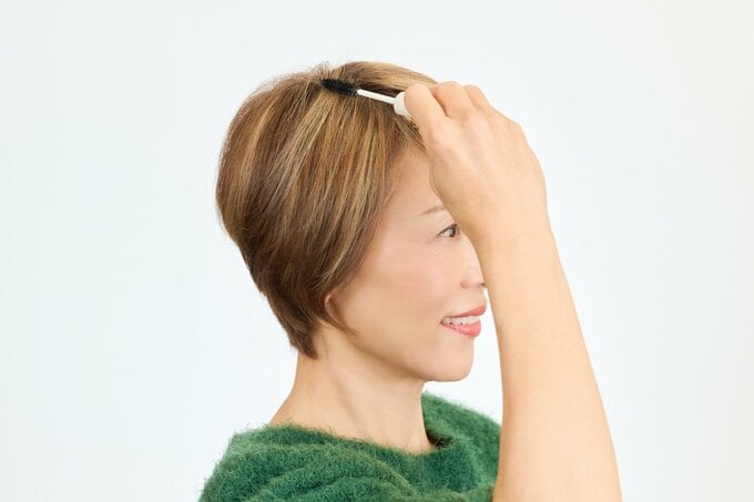 アホ毛をおさえる女性