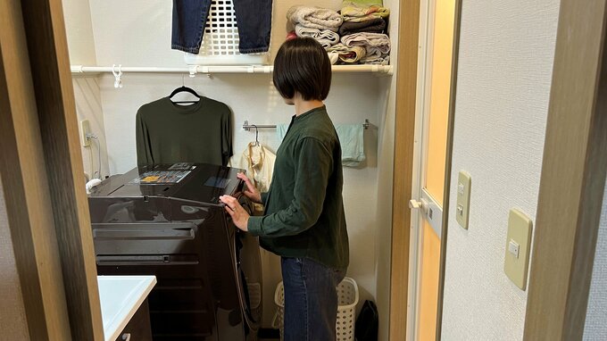 洗濯機の前に立つみさきさん