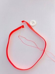 きれいな色の刺しゅう糸でボタンを縫いつけるだけです。