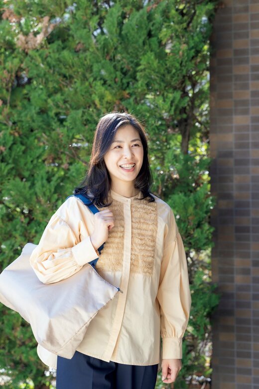 バッグを肩にかけて歩く女性