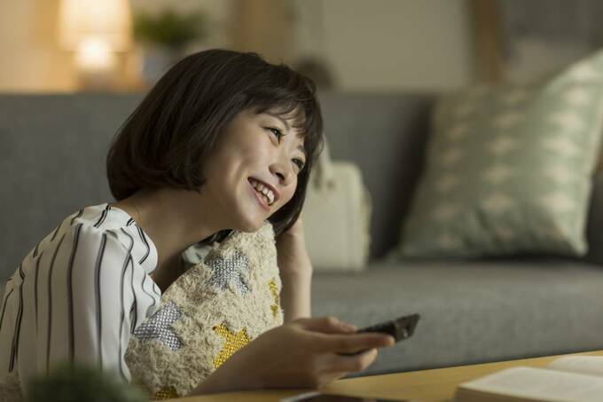 リモコンを持つ女性