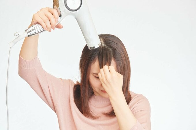 前髪を乾かす女性