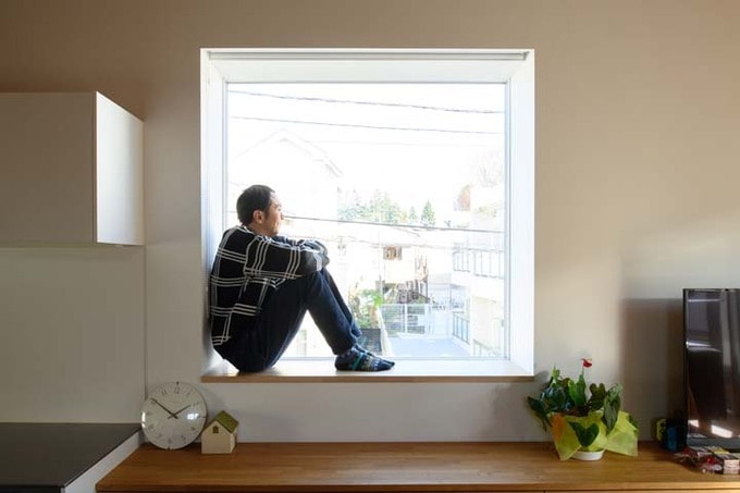 正方形の出窓に座る田中さん