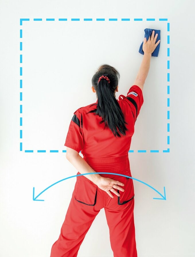 タオルで壁をふく新津さん