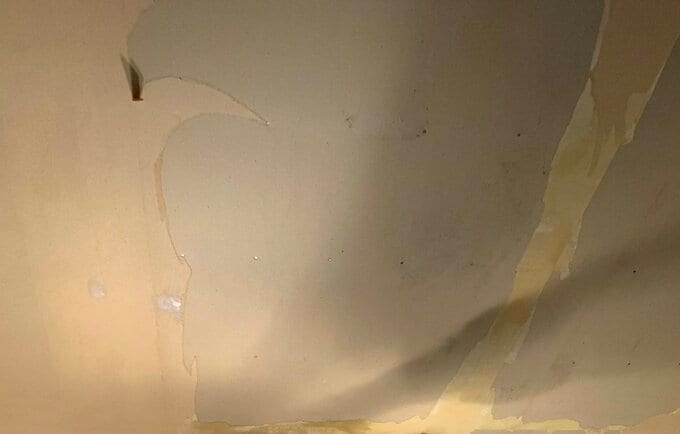 布製の壁紙を半分はいだ天井