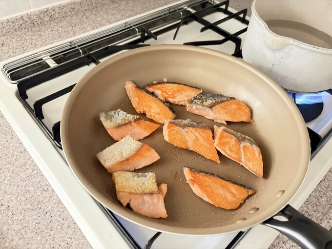 フライパンで鮭を焼く様子