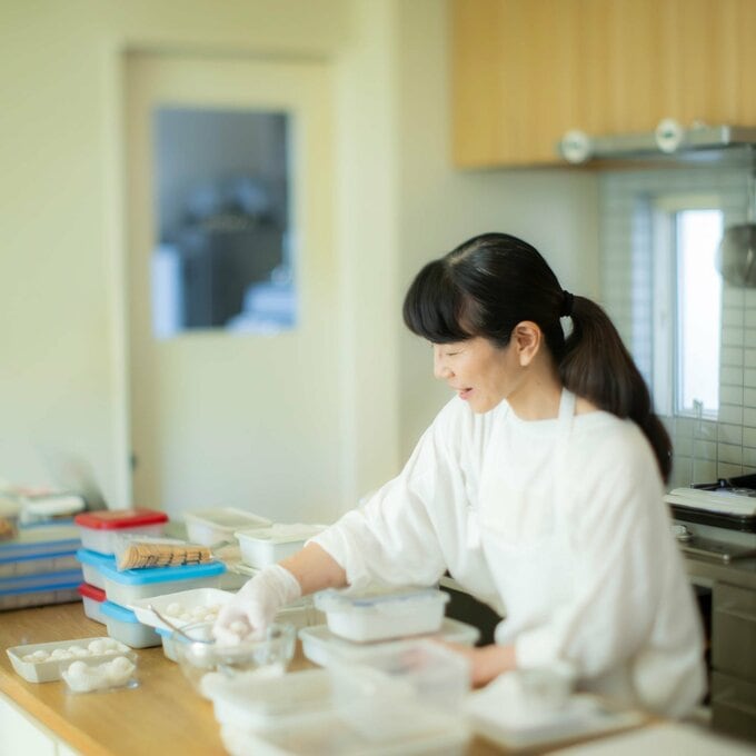 スノーボールクッキーの仕上げをする本間節子さん