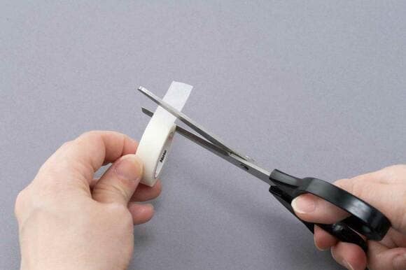 テープをハサミで切る