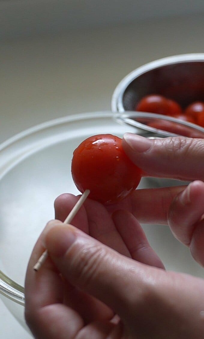 ミニトマトのヘタを取り、洗ったら、ヘタの反対側に爪楊枝で穴をあける。