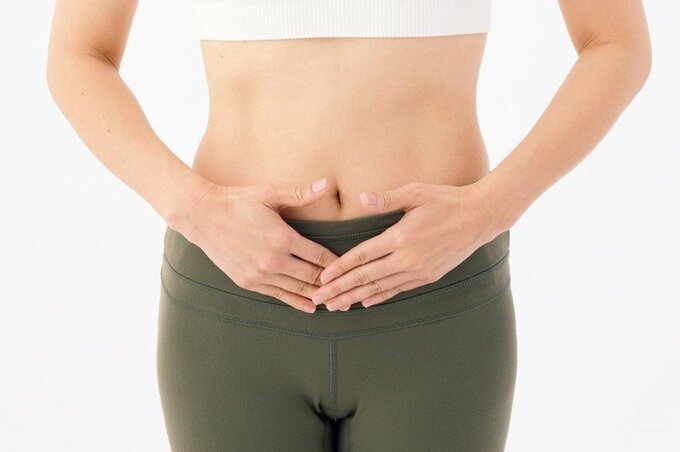 関元のツボに両手を当てる様子