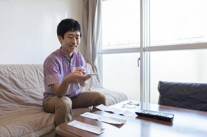 男性の目の前テーブルにレシート