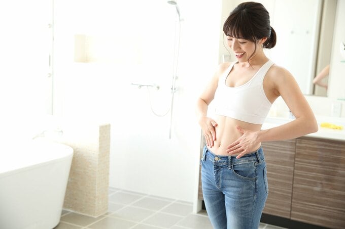 お腹を見る女性