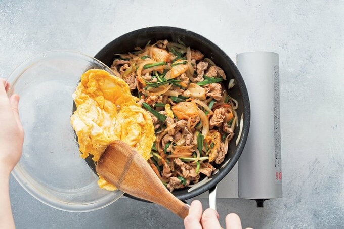 フライパンに卵を追加する様子