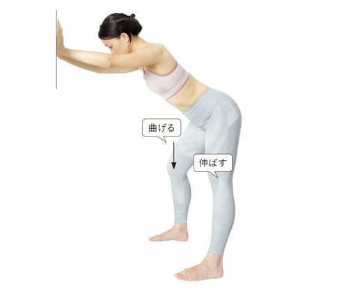 壁に手をついてお尻を突き出し、左脚を伸ばしている女性