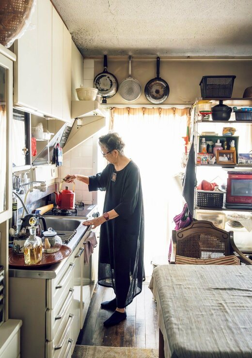 キッチンでやかんを沸かす女性
