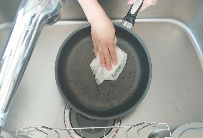 ふきんでフライパンを洗う