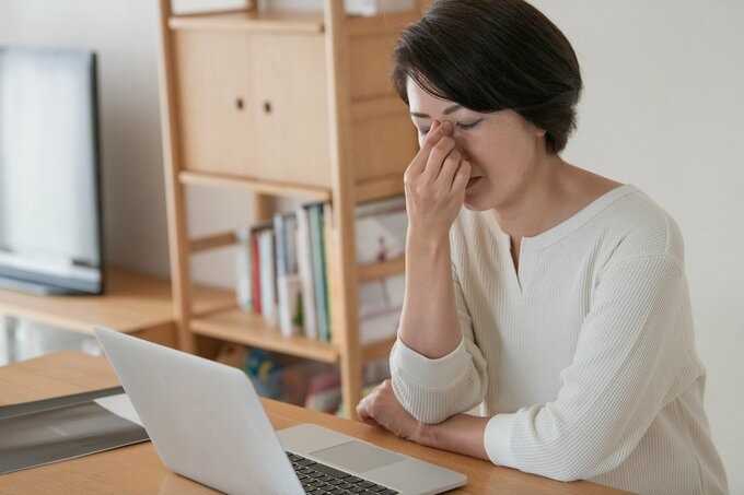 目を抑える女性