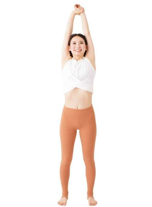 手を上げて立つ女性